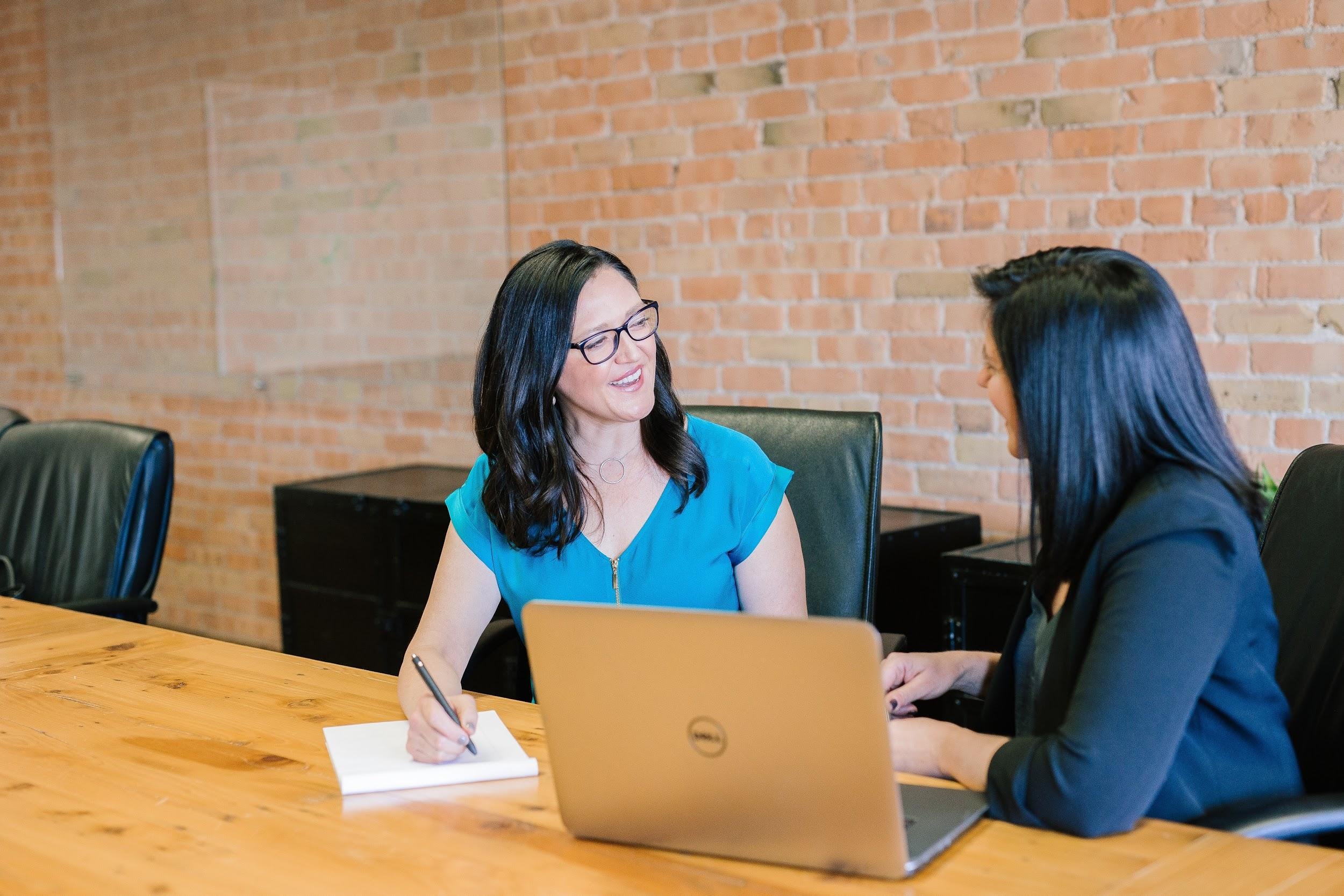 Two women talking by a desk