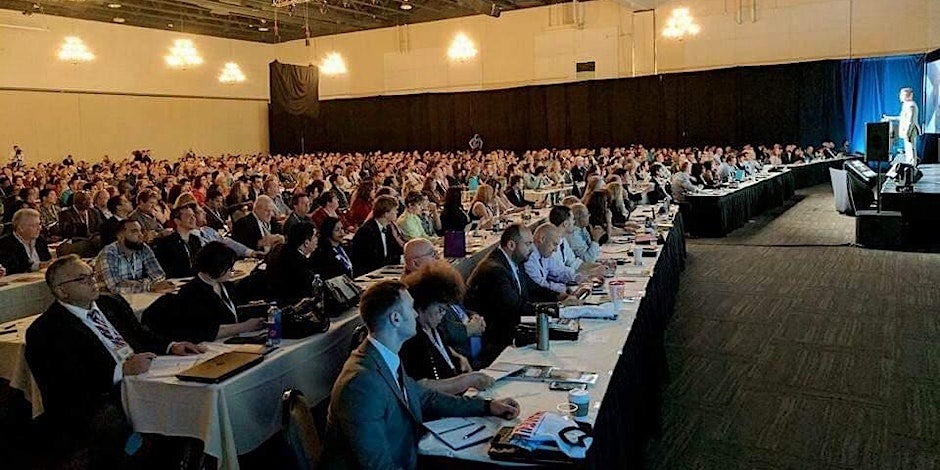 Speaker standing on a stage in front of a large audience