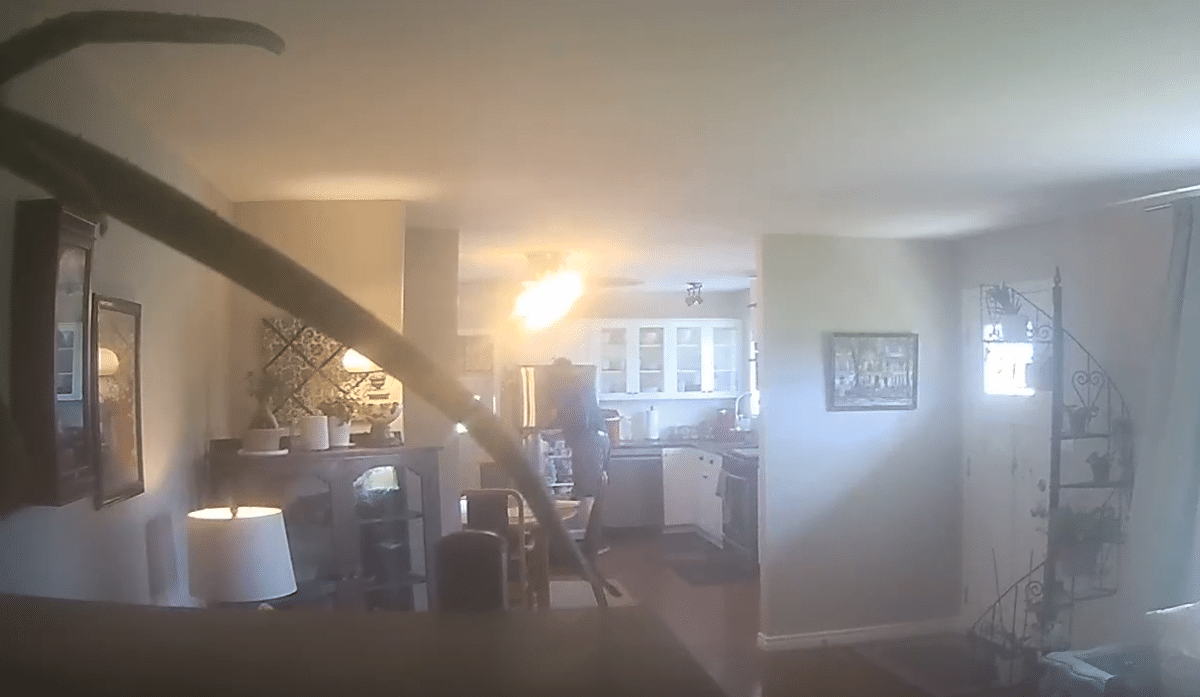 Screenshot of a man caught on camera drinking milk from a homeowner's refrigerator.