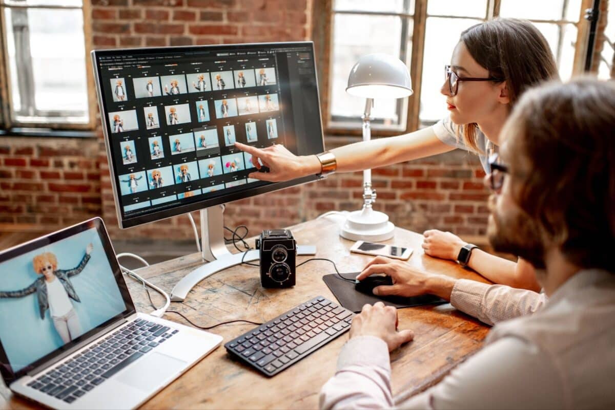  Photographers editing a woman's portraits with two computers in the studio