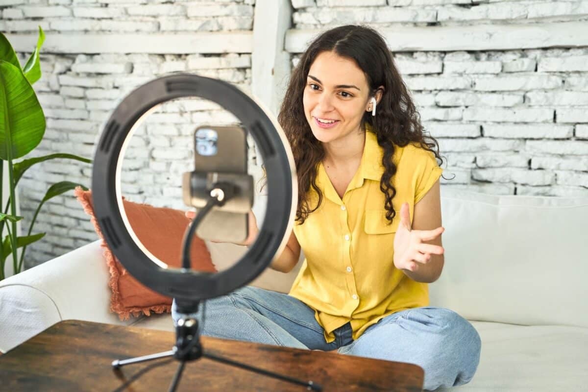 A real estate professional recording a vlog in front of a ring light and mobile phone