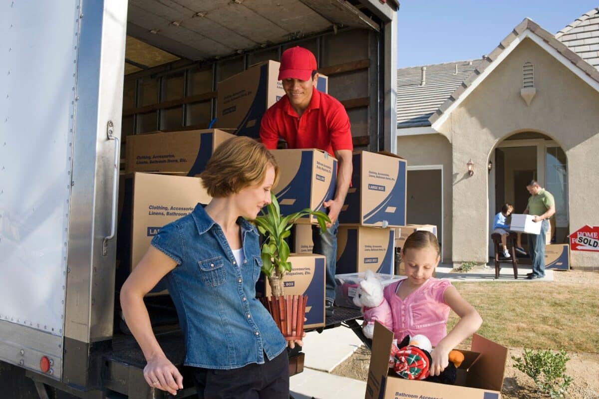 Homeowners working with a mover to load a truck with their belongings.