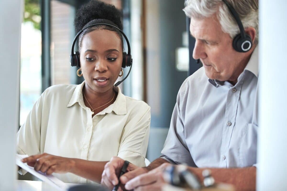 Woman mentoring a man on a phone call. 