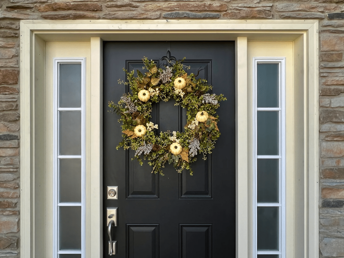 A spring-themed wreath hanging on a black door