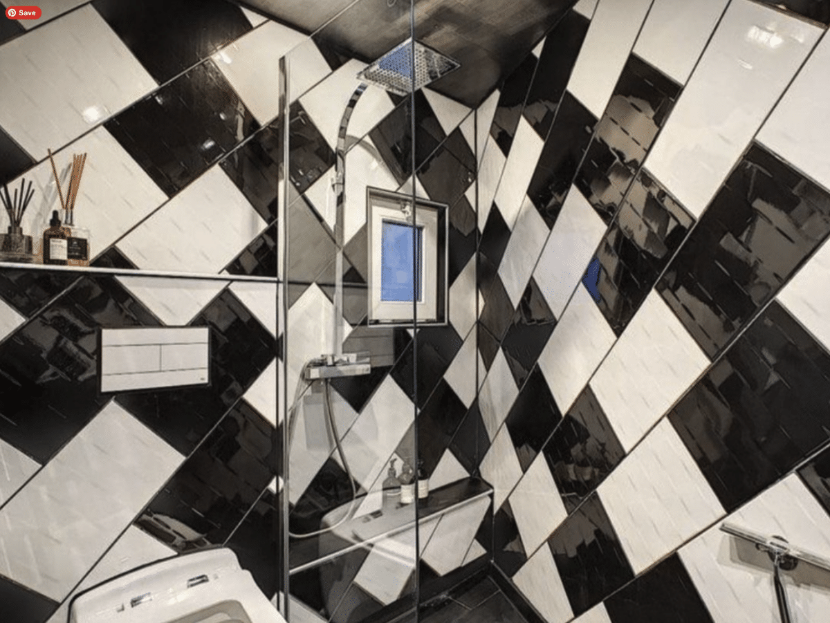 Black and white tiles in a bathroom with clear glass doors for the shower.