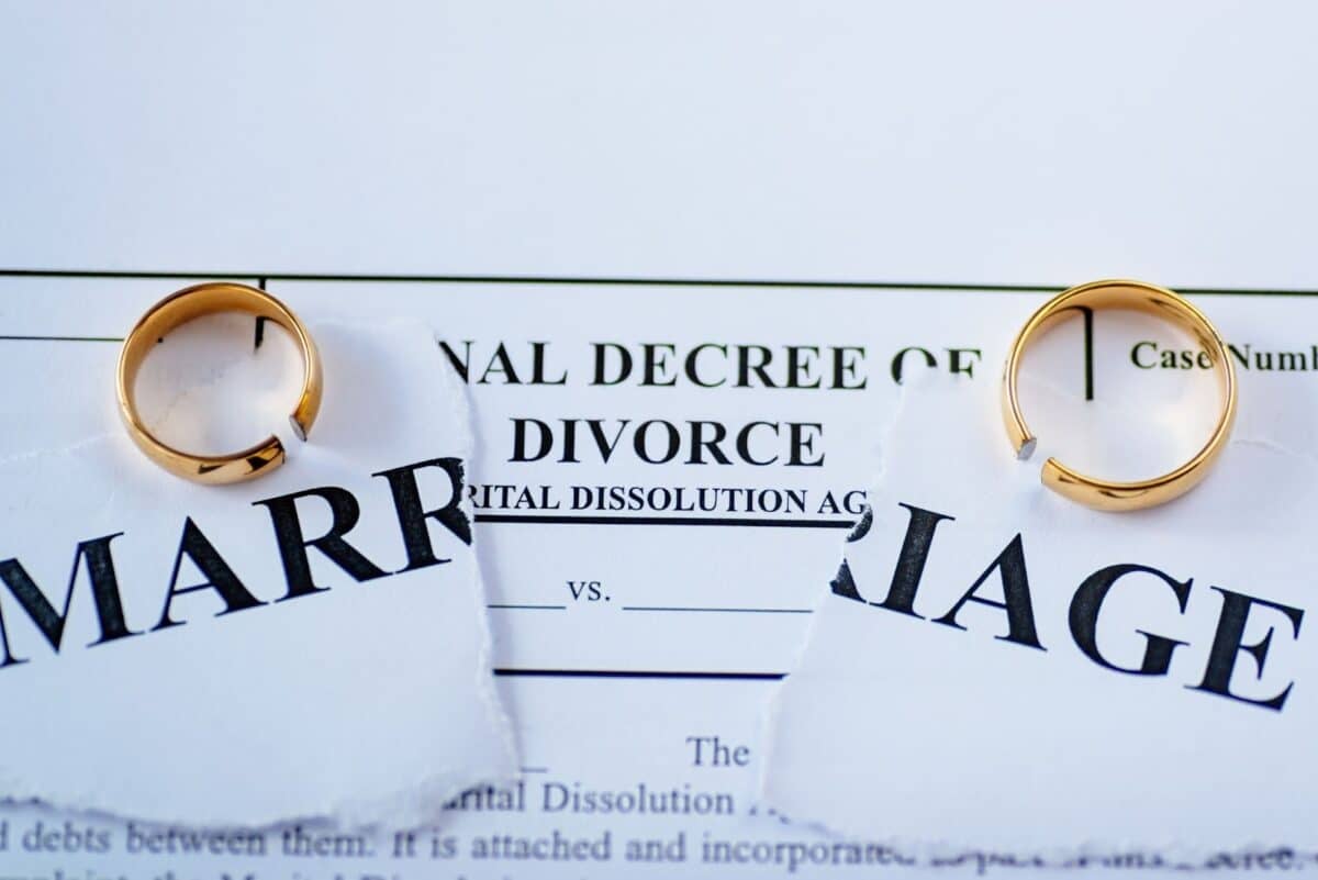 Divorce decree and two broken wedding rings.