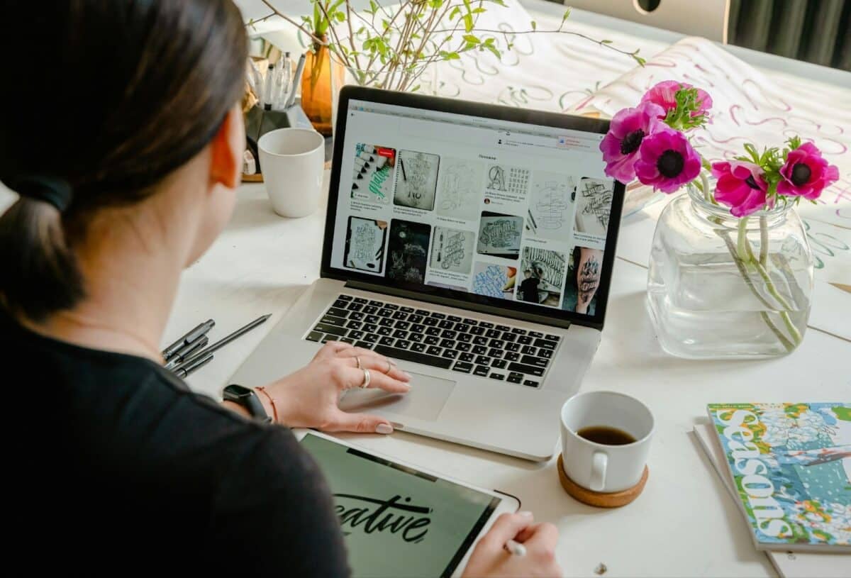 woman at her desk working on a computer creating online content.