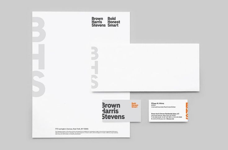 Design layout with white business card with bold black lettering and subtle orange accents