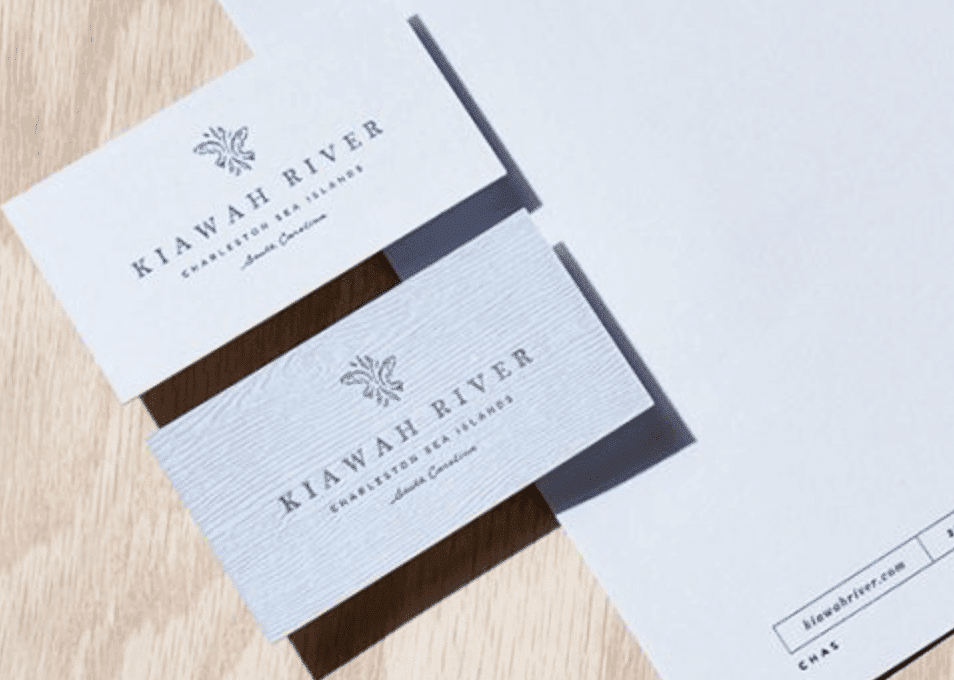 White business card with grey font and a woodgrain texture