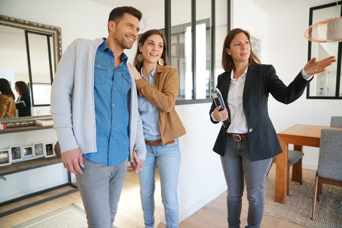  A real estate agent showing a couple a home.