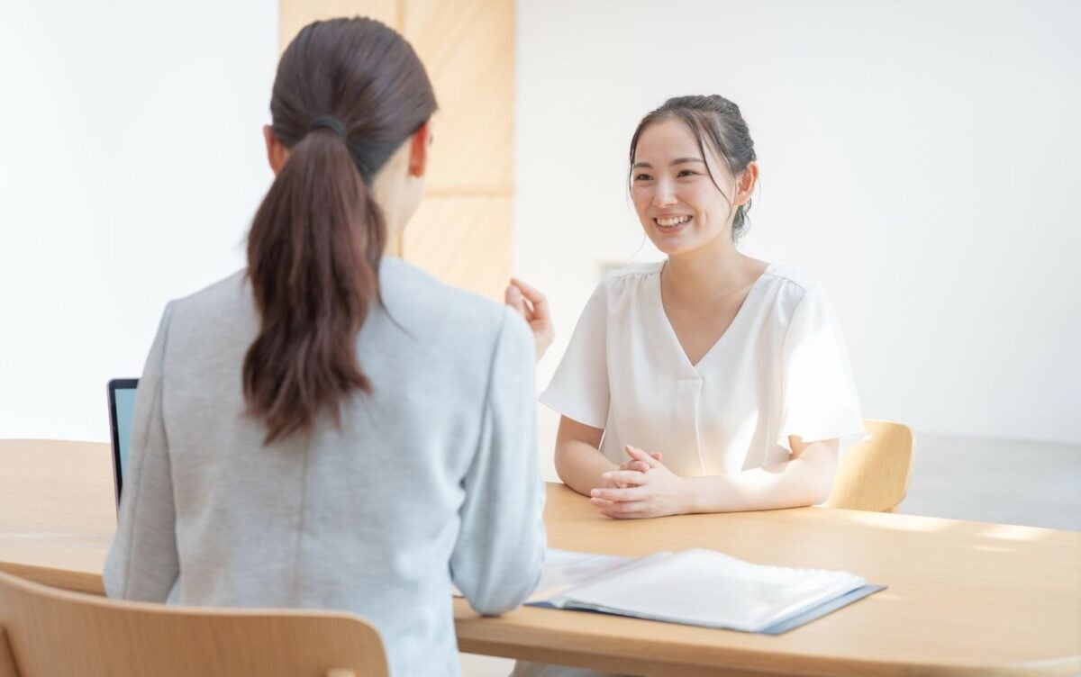 Two people sitting at a table facing each other and having a discussion.