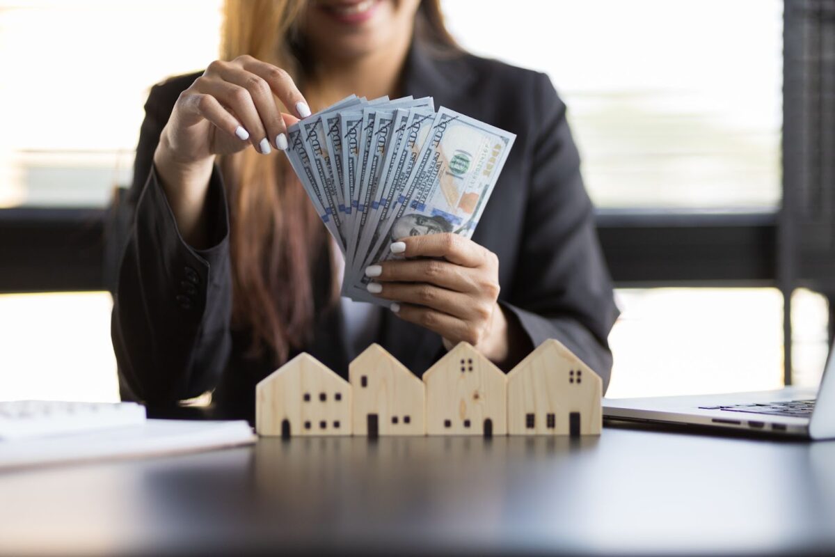 A person holding money while sitting at a table.