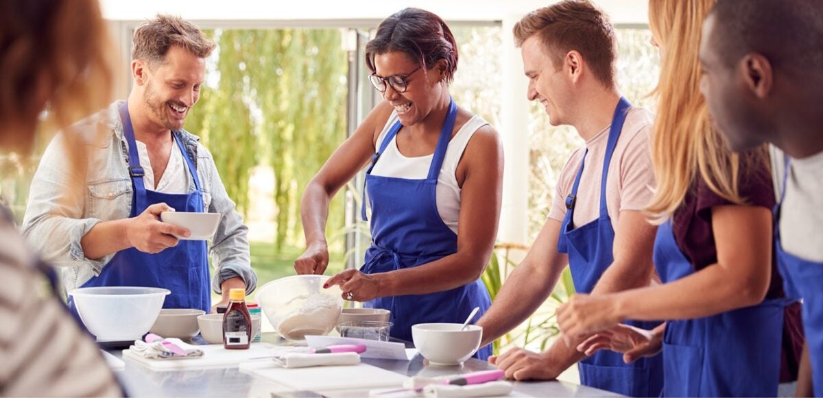 A group of six men and women in a cooking class.