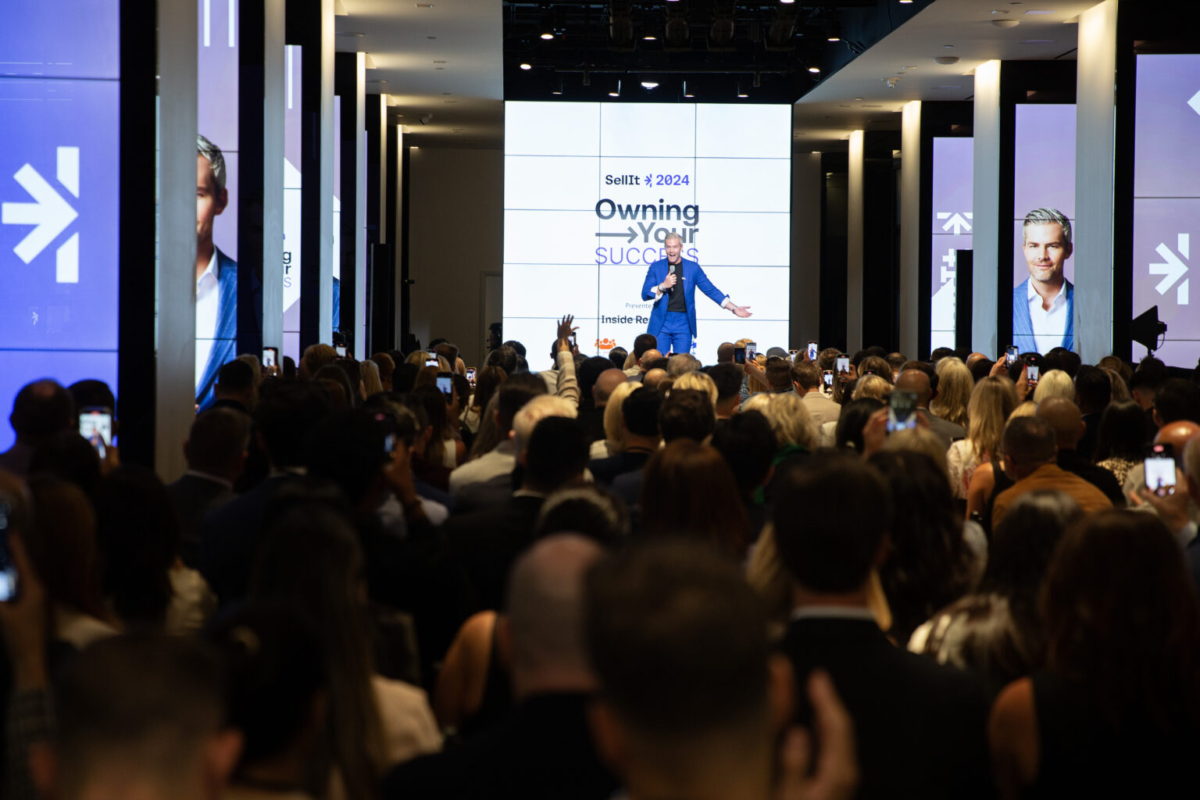 Ryan Serhant speaking on stage in front of a crowd.