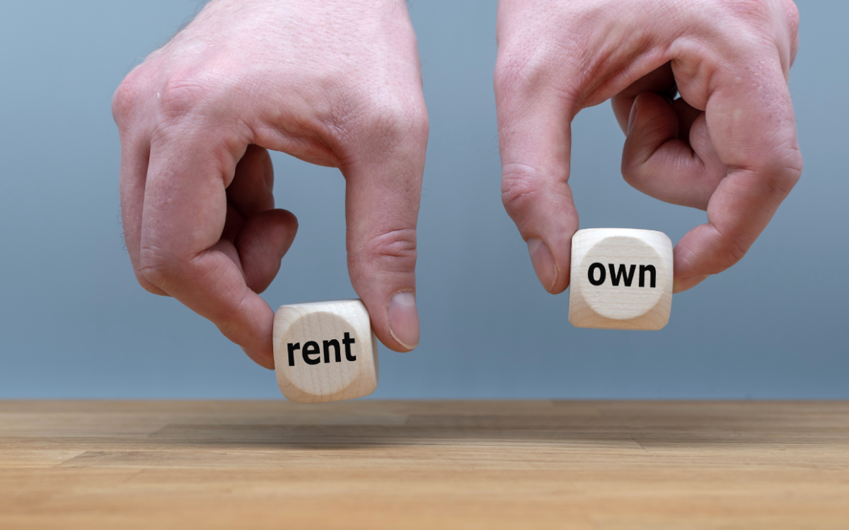 Hands holding dice that read "rent" and "own."