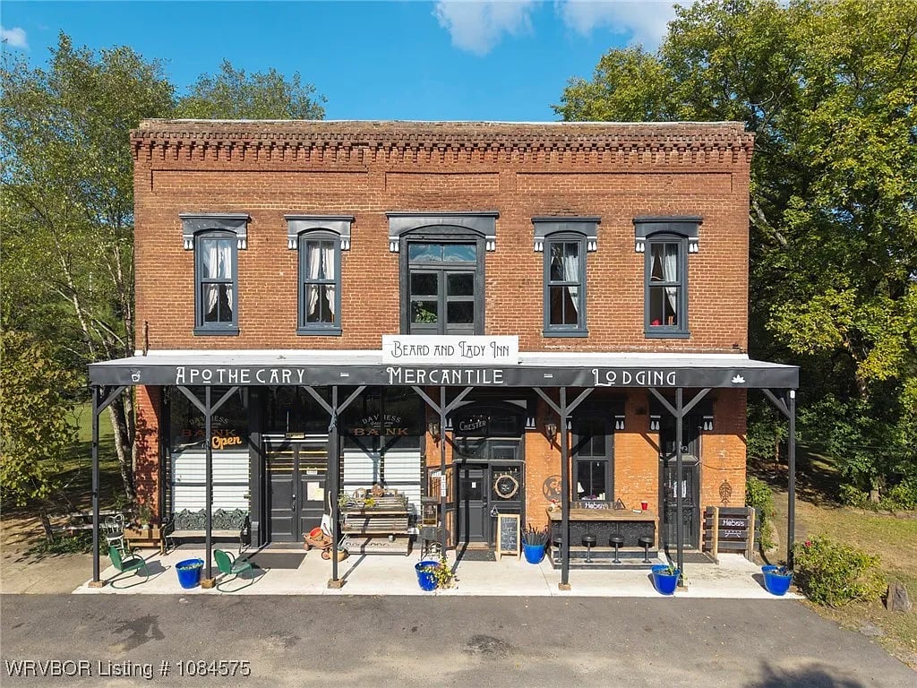 The exterior of a brick historic hotel with an apothecary shop on the first floor.