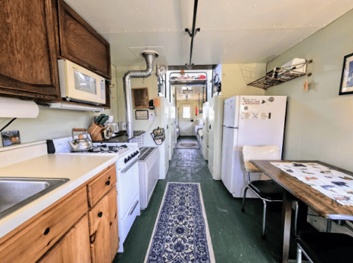 The kitchen inside the train which is skinny and tight.