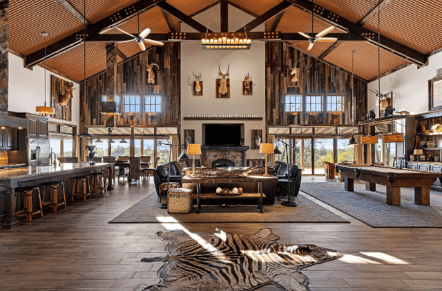 Inside of the home with a zebra rug, deers hung on the walls, and a pool table.