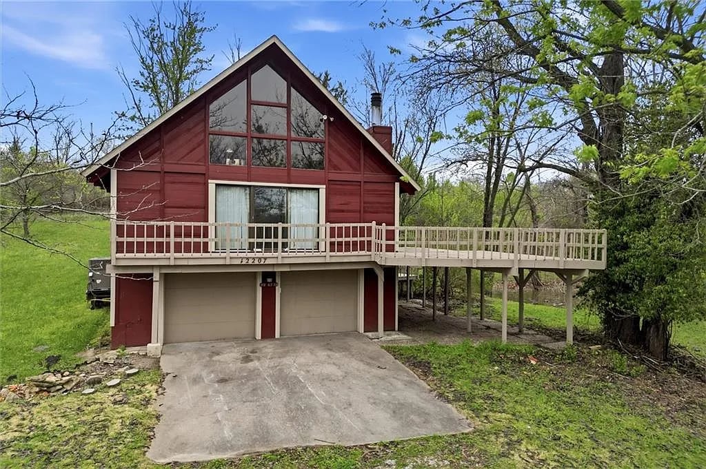 A red home with a raised deck.