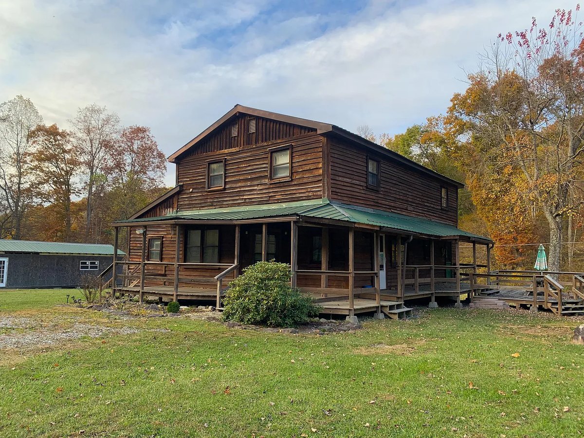 A brown two story cabin with green roof.
