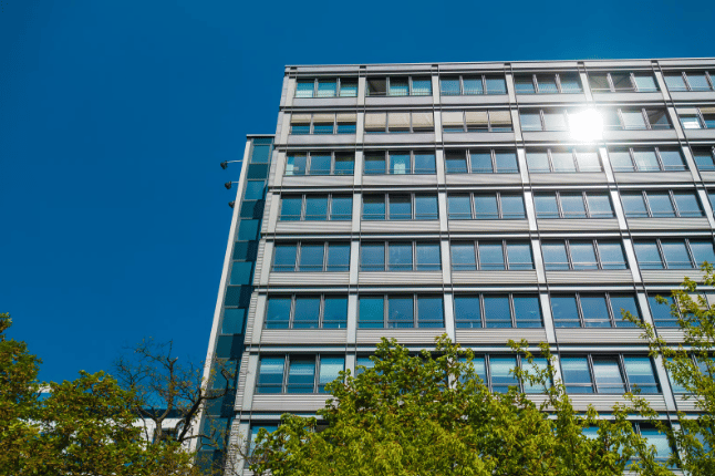 A blue glass office building in front of a blue sky